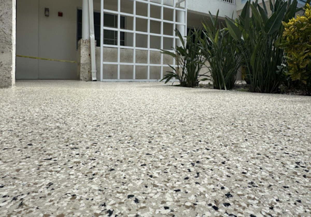 White flake epoxy walkway alongside tropical landscaping
